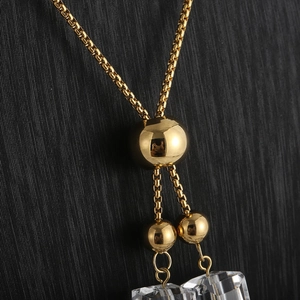Detail of adjustable gold-plated chain with two transparent rectangular crystal pendants