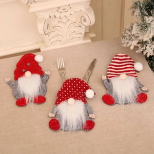 Gnome Christmas cutlery holders set with red hats and white beards on linen tabletop