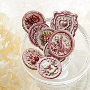 Vintage relief stickers with cat and rose patterns displayed in a glass bowl