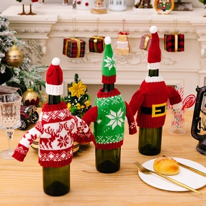 Three Christmas knitted wine bottle covers with reindeer and snowflake sweater patterns