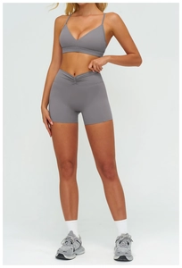 Dettaglio del set yoga grigio con reggiseno sportivo a V e pantaloncini a vita incrociata