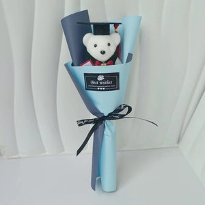 Detail of graduation teddy bear with sunflower soap flowers in blue wrapping paper