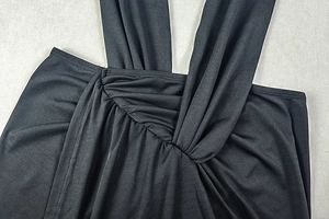 Détail d'une robe dos nu noire avec nœud croisé et texture plissée élégante