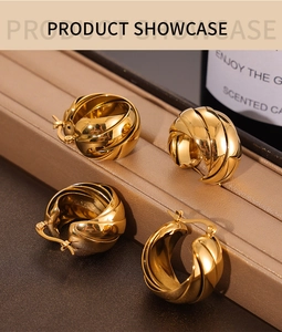 Close-up of gold-plated twisted hoop earrings on a luxury jewelry showcase background