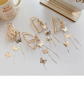 Detail of golden metal hair claws with elegant butterfly designs and hanging tassels