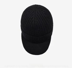 Vista dall'alto di un cappello invernale nero a maglia con trama a coste e placchetta