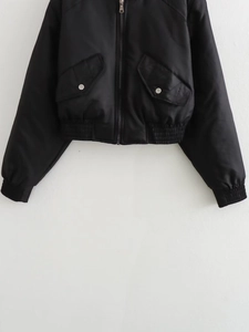 Detail of black bomber jacket featuring metallic zipper and ribbed cuffs with large pockets