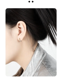 Detail showing two-tone gold and silver circular hoop earring worn on a female model