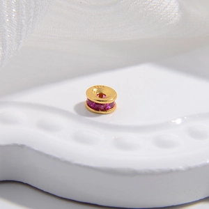 Dettaglio macro del distanziatore in argento S925 dorato con zirconi rossi incastonati