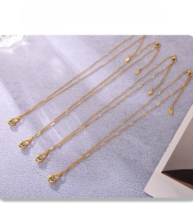 Macro view of gold PVD plated heart pendants with blue turquoise beads on thin chains