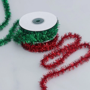 Festive red and green metallic Christmas tinsel ribbons on white spools for DIY decor