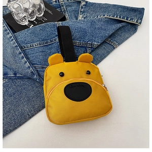 Detail of yellow cartoon bear handbag showing fabric texture and sturdy black strap