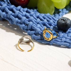 Close-up of abstract bicolor titanium steel rings on white surface with grapes