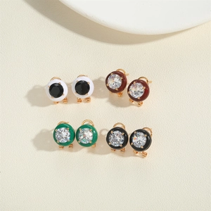 Detailed macro view of four pairs of round stud earrings with multi-color rhinestones