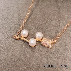 Elegant rose gold necklace with pearls and zircon leaf pendant on grey velvet background
