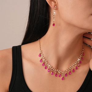 Luxe gold jewelry set with pink teardrop gems and crystals shown on model