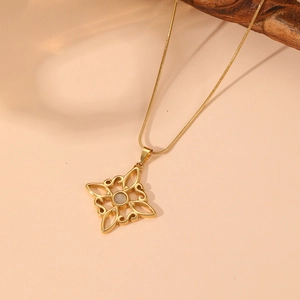 Macro view of gold hollow square knot pendant with cat eye stone and cubic zirconia details