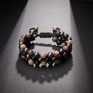Détail du bracelet tissé double couche ajustable avec pierres noires et perles roses