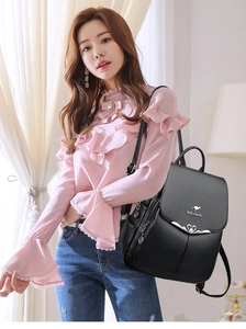 Detail view of black leather backpack featuring kangaroo logo and heart-shaped clasp on a model