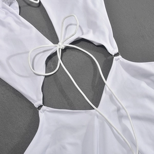 Détail des cordons blancs et des anneaux métalliques sur une robe élastique blanche