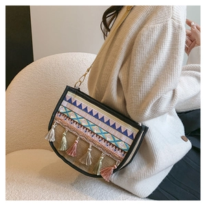 Close-up of bohemian linen bag with ethnic embroidery and colorful tassel fringe