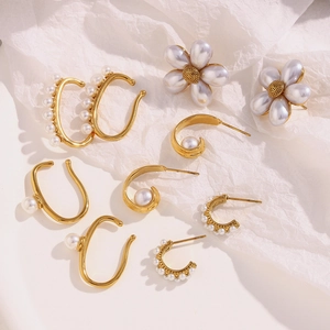 Detailed macro shot of vintage 18K gold-plated pearl flower earrings and ear cuffs