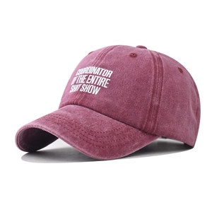 Detail of vintage washed cotton baseball cap with white slogan print in burgundy red