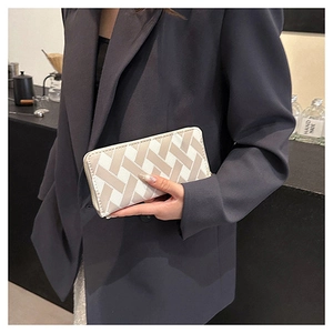 Macro detail of fashionable woven clutch wallet featuring beige geometric texture