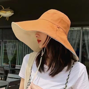 Dual-color wide brim sun hat with windproof rope shown on model in outdoor setting