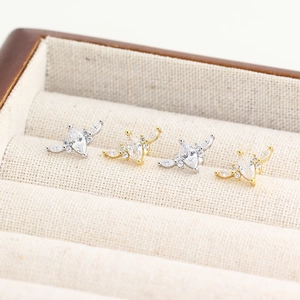 Gros plan de boucles d'oreilles papillon en argent S925 avec zircons dorés et argentés