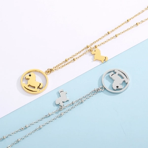 Detail of hollow pony pendant necklaces in gold and silver finishes on a split background