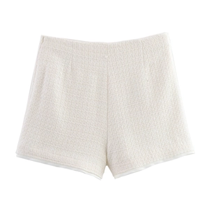 Detail of cream white tweed shorts with rich woven texture and elegant clean minimalist cut