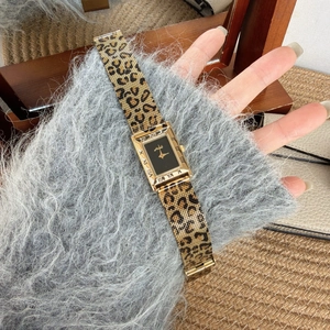 Detail of retro gold rectangular quartz watch with leopard print metal mesh strap