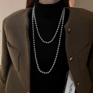 Detail shot of double-layer grey faux pearl long necklace on a brown blazer outfit