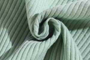 Detail shot of mint green ribbed cotton fabric showing soft texture and vertical patterns