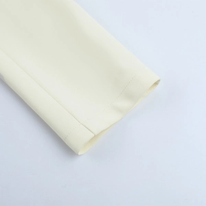 Close-up detail of beige twill suit fabric texture and precise stitching on the sleeve cuff