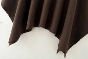Detailaufnahme von dunkelbraunem Strickstoff mit weichem Fall und strukturierter Kante