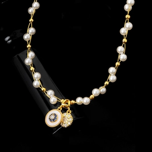 Détail du collier plaqué or 18k avec perles et pendentifs circulaires en zircon