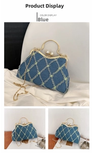 Detailed close-up of blue denim shell bag featuring quilted stitching and pearl clasp