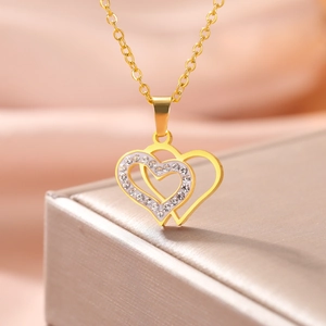 Close-up of golden double heart pendant with sparkling cubic zirconia on luxury gift box