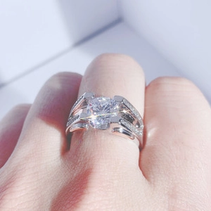 Detail of a sparkling silver ring with a large round diamond center on a double band