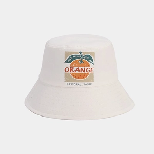 Vue détaillée de l'imprimé orange et du texte sur un chapeau bob en coton blanc