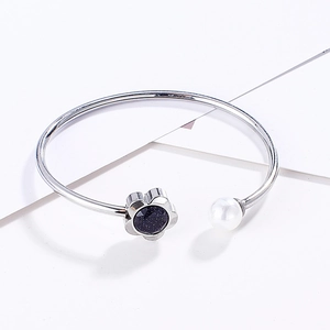 Detail of silver flower bangle featuring dark blue sandstone and white faux pearl