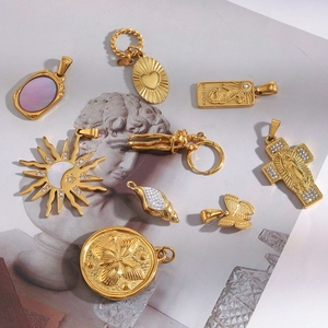 Flat lay of 18K gold plated stainless steel pendants with sun, heart and shell details