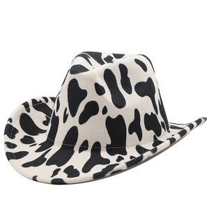 Detail shot of cowboy hat featuring thick fabric and black white cow print pattern