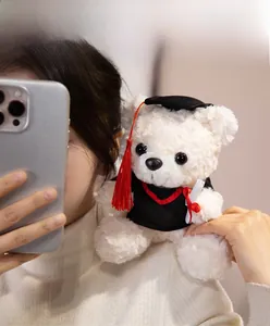 Close-up of a white graduation teddy bear in black cap and gown for souvenir gift