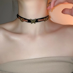 Detail of vintage choker necklace featuring bronze butterfly pendant and leather stitching