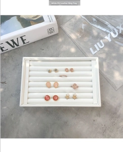 Vue détaillée de dessus du plateau à bijoux en cuir PU blanc avec 7 fentes pour bagues et boucles