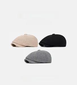 Detail shot of vintage knit newsboy caps in beige black and grey wool texture