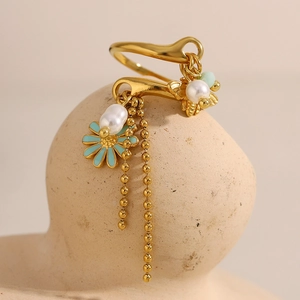 Detail of 18K gold ring with blue enamel daisy flower and hanging pearl tassels